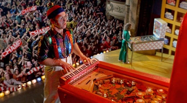 Elton John em "Pinball Wizard" da banda de rock britânica The Who como parte de sua ópera rock “Tommy“.