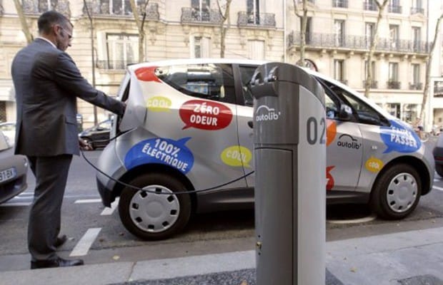 Homem em ponto de abastecimento de carro elétrico em Paris. Foto: AFP.