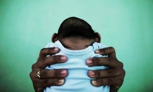 Jackeline detém o filho de 4 meses de idade que nasceu com microcefalia, na frente de sua casa em Olinda, Pernambuco. Foto: Nacho Doce