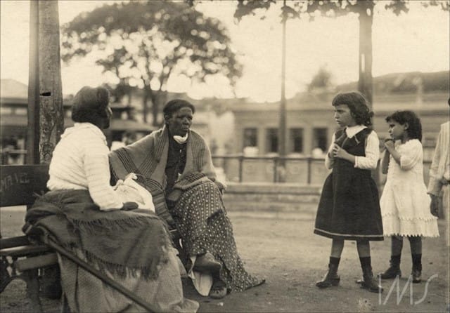 Duas mulheres, uma de costas, descansando em banco de praça, cerca de 1910. Foto: Vincenzo Pastore / Acervo IMS.