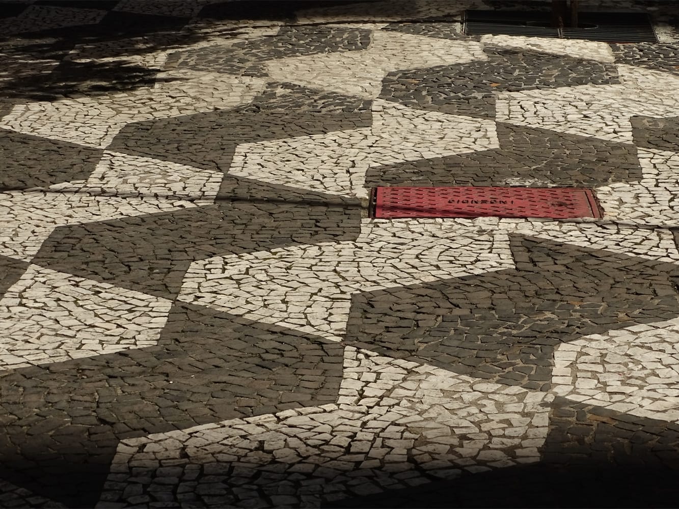 A padronagem apresenta duas versões materiais, em lajota e pedra portuguesa seguindo o mesmo padrão de cores. Foto: Rene de Paula / Flickr.