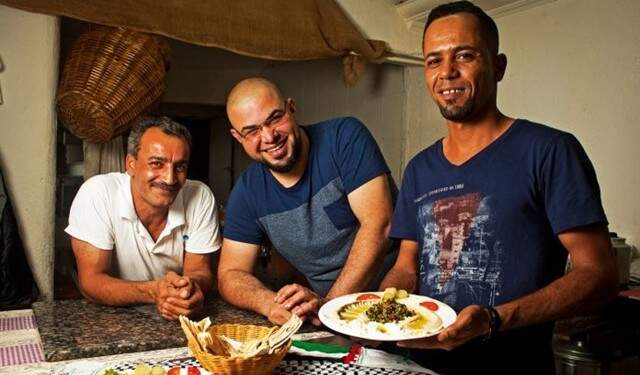 O sírio Rami Othman (centro), ao lado de colegas de cozinha do restaurante Al Janiah, em São Paulo: talentos culinários dos refugiados estão em alta. Foto: Felipe Gabriel.