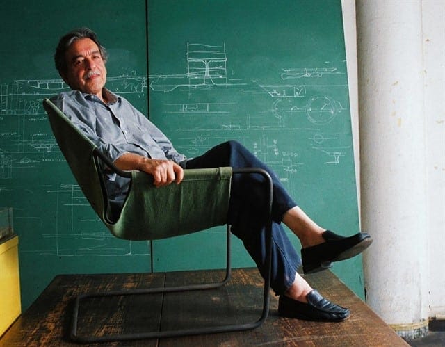 Paulo Mendes da Rocha em seu escritório sentado na cadeira paulistana, de sua autoria; 2005. Foto: Ana Ottoni.
