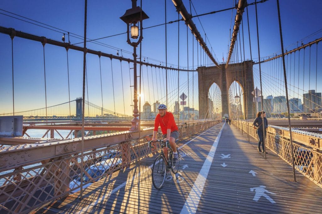 Ciclista na ponte do Brooklyn, em Nova York. Foto: Michele Falzone / Getty Images.