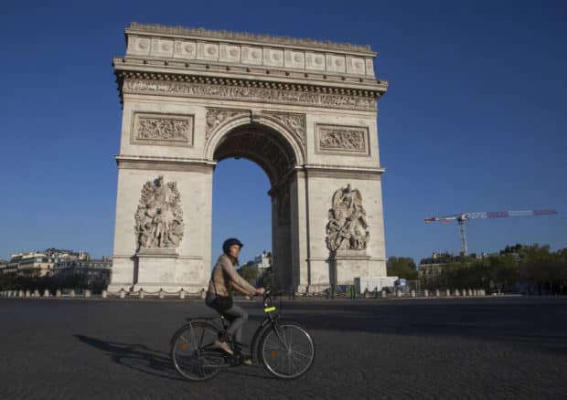 Ciclista passeia perto do Arco do Triunfo em uma Paris vazia em meio à pandemia. Foto: Getty Images.