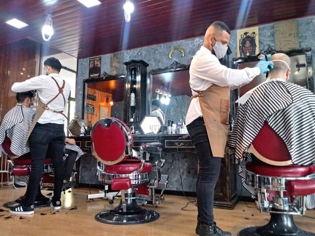 Em barbearias, os profissionais devem trabalhar equipados com luvas, máscaras e, dependendo do procedimento, viseiras. Foto: João Fortes / BBC.