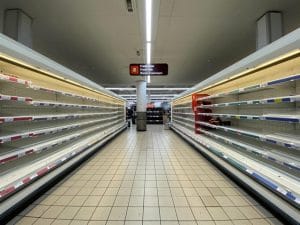 Medo da recessão econômica causada pela pandemia de COVID-19 fez com que prateleiras em supermercados do mundo todo ficassem vazias. Foto: John Camero / Unsplash.