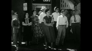 Nos EUA, década de 1960 grupo de pessoas espera na calçada para atravessar a rua em Nova York. Imagem: Videoblocks.